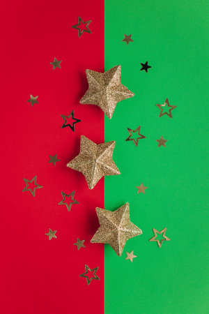 Golden sparkling stars on a red and green background. flat lay. Place for text.の写真素材
