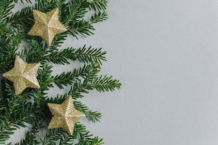Beautiful Christmas ornaments and spruce branches on a gray background. flat lay. Place for text.の写真素材
