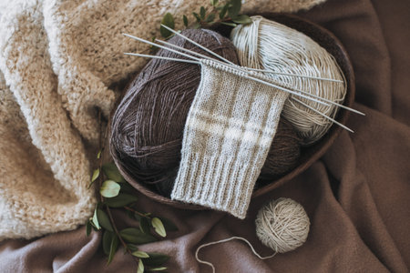 Hand knitted socks with needles and yarn ball in a basket. Concept for handmade and hygge slow life.