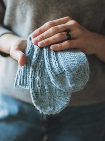 Female hands with cozy hand knitted socks. selective focus.