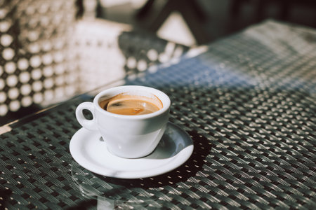 Cup of black coffee on a table in a street cafe. selective focus. Place for text.