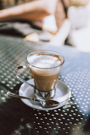 Cup of coffee latte on a table in a street cafe. selective focus.の写真素材