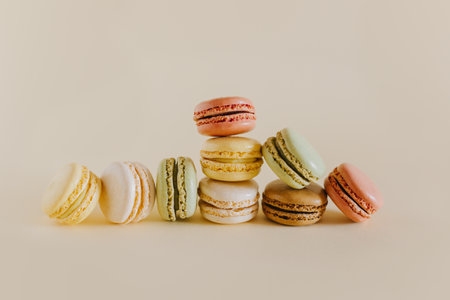 Tasty french macarons on a peach pastel background. Place for text.の写真素材