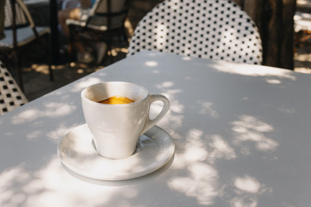 Cup of black coffee on a table in a street cafe. selective focus. Place for text.の写真素材
