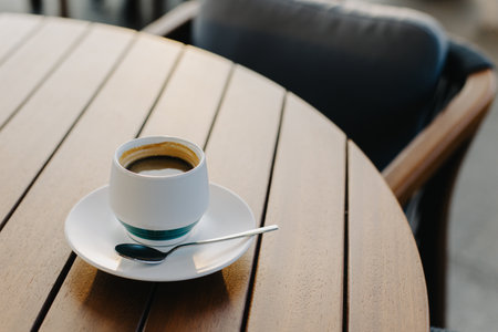 Cup of black coffee on a wooden table in a cafe. Place for text.