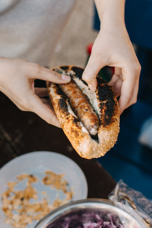 Woman cooking a delicious hotdog on a grill picnic outside. Selective focus.の写真素材