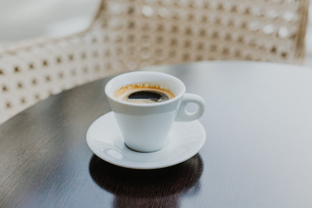 Cup of black coffee on a wooden table in a street cafe. Place for text.の写真素材