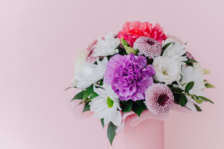 Beautiful bouquet of pink. violet and white flowers on a pink pastel background. Place for text.の写真素材