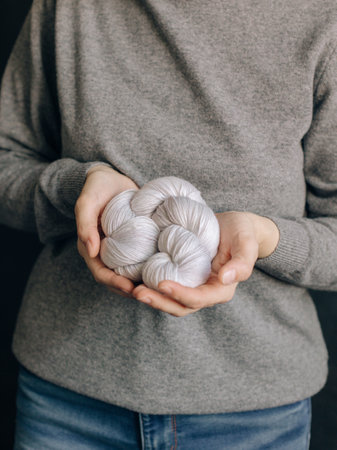 Female hands with yarn skein for knitting. Selective focus.の写真素材