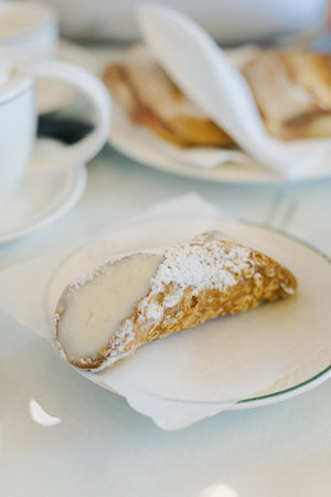 Sweet cannoli stuffed with cream for breakfast on a table in a cafe. Italian pastry.の写真素材