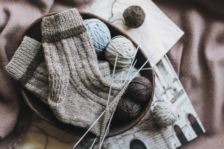Hand knitted socks with needles and yarn ball in a basket. Concept for handmade and hygge slow life.の写真素材