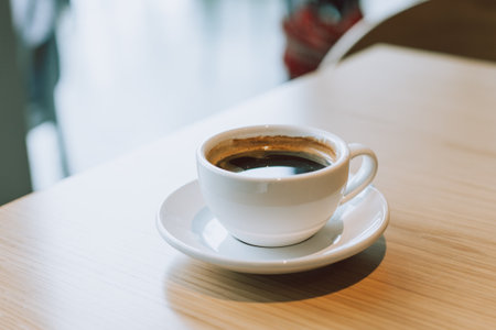 Cup of black coffee on a wooden table in a street cafe. Place for text.の写真素材
