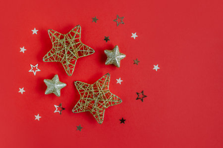 Golden sparkling stars on a red glittering background. flat lay. Place for text.の写真素材