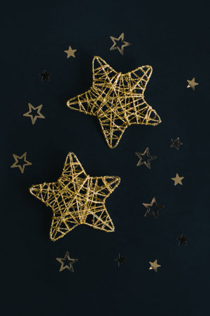 Golden sparkling stars on a black background. Flat lay. Place for text.の写真素材
