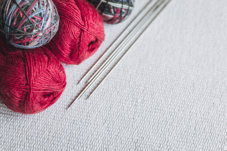 Skeins of wool yarn and needles for hand knitting on a gray background. Concept for handmade. Place for text.の写真素材