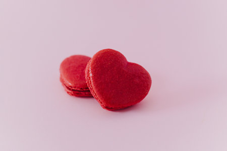 Pink heart shaped French macarons on a pink pastel background. Concept for Valentine's day. Place for text.の写真素材