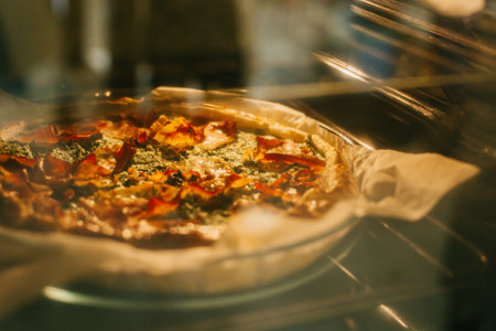 Traditional Italian pie with cheese and ham in an oven. Selective focus.の写真素材