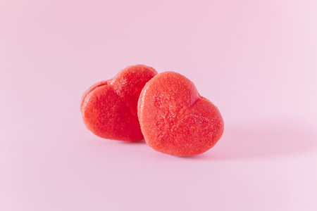 Pink heart shaped French macarons on a pink pastel background. Concept for Valentine's day. Place for text.の写真素材