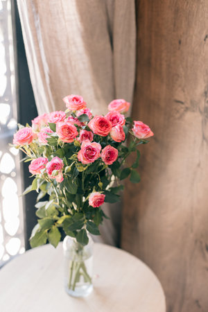 Tender pink Rose flowers in a vase near the window. Daylight.の写真素材