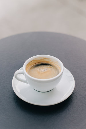 Cup of black coffee on a table in a street cafe.の写真素材