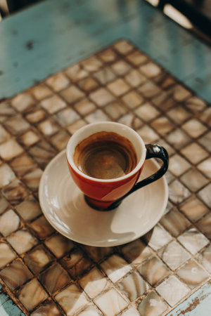 Red ceramic cup of aromatic black coffee on a table in a street cafe. Top view.の写真素材