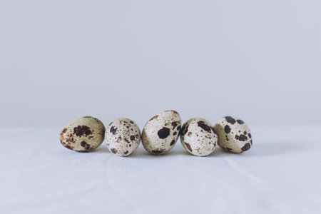 Quail eggs on a white background. Minimal eco concept. Easter modern background. Place for text.の写真素材