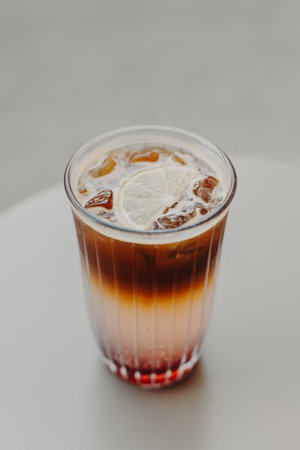 Glass of refreshing summer cocktail with lemon and ice on a table. Cocktail with ice, coffee and lemon slices. Place for text.の写真素材