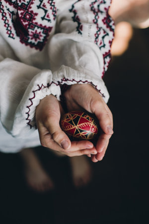 Traditional Ukrainian Easter eggs Pysanka in black, red and white colors in a girls hands. Ukrainian art. Modern minimalism.の写真素材