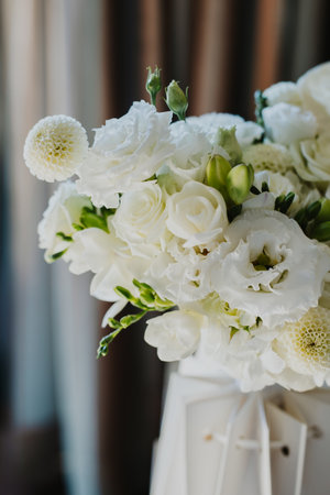 Delicate wedding bouquet of white flowers Freesia, Roses in a morning sunlight. Selective focus.の写真素材