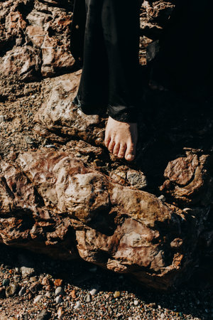 Close up female feet by the sea. Top view of a young woman's bare feet in a water on a beach.の写真素材
