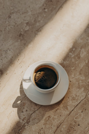 Cup of black coffee on a marble table in a street cafe. Flat lay. Place for text.の写真素材