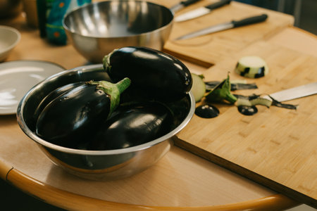 Ripe eggplants in a bowl on a kitchen table. Close-up.の写真素材