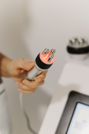 Cosmetologist in pink glove holds an RF lifting device at cosmetology clinic. Close up. Cosmetology...