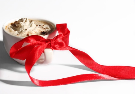 cup of coffee with cream and red bowの写真素材