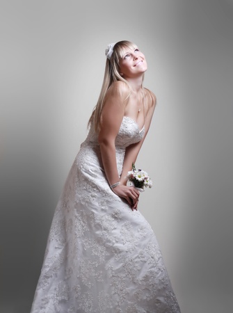 beautiful young woman in a white dress with a bouquet of flowersの写真素材