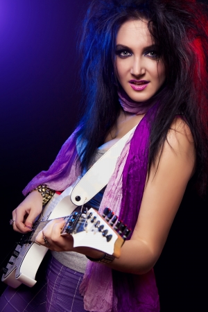beautiful young rock guitarist on a black backgroundの写真素材