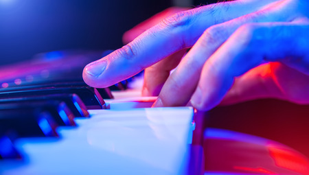 hands of musician playing keyboard in concert with shallow depth of fieldの写真素材