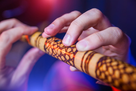 Folk musician in concert plays the melody on the Ethnic Fluteの写真素材