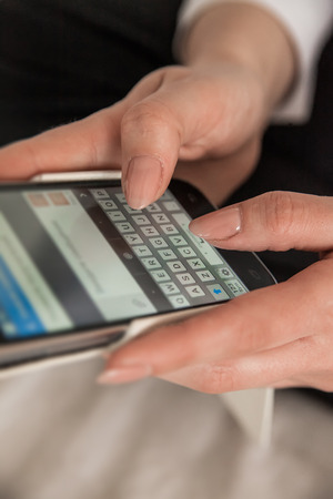 Close up of woman hands sending sms on smartphoneの写真素材