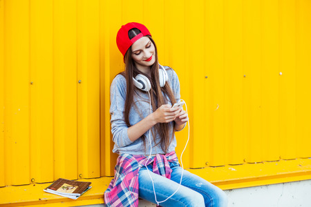 Portrait of Dreamy Young attractive Teenager in Urban background Listening to Music with from Smartphoneの写真素材