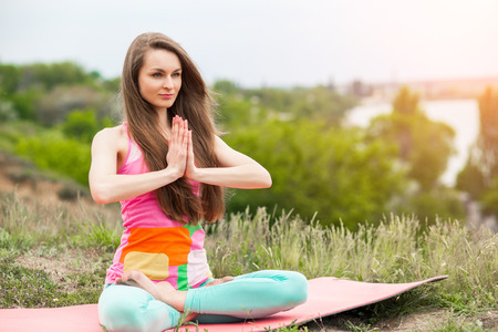Peaceful healthy & fit young woman meditating on the natureの写真素材