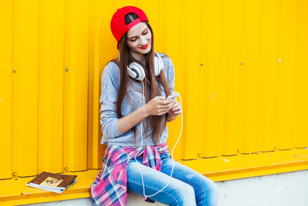 Portrait of Dreamy Young attractive Teenager in Urban background Listening to Music with from Smartphoneの写真素材