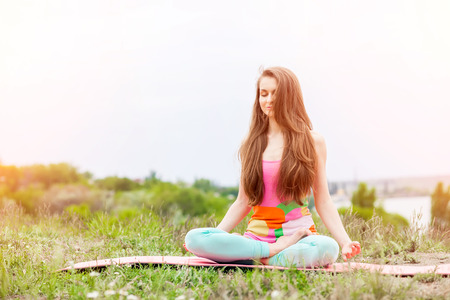 Peaceful Healthy & Fitness Young Woman Meditating on the nature with eyes closedの写真素材