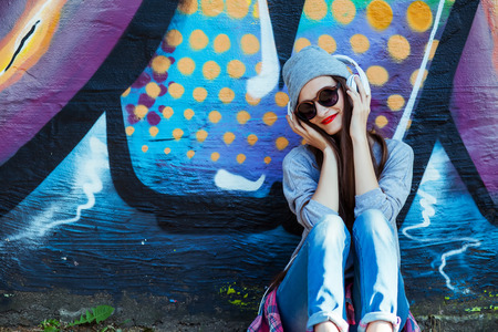 Portrait of Young attractive Teenager in Urban background Listening to Music on smart phoneの写真素材