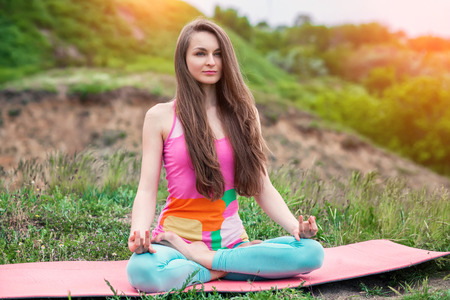 Peaceful healthy & fit young woman meditating on the nature with eyes closedの写真素材