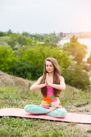 Peaceful healthy & fit young woman meditating on the nature with eyes closedの写真素材