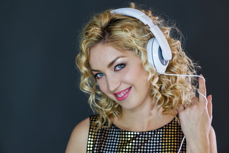 Woman with headphones on, touching the earcupsの写真素材