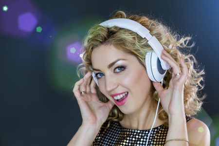 Woman with headphones on, touching the earcupsの写真素材