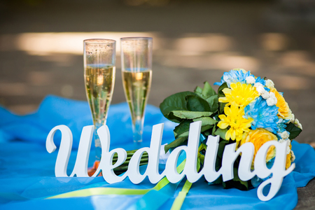 Word of wedding and bridal bouquet and glasses with champagneの写真素材