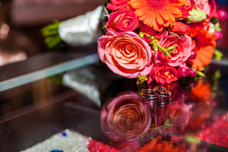rings and beautiful tender bridal bouquet from different roses and other flowers close upの写真素材